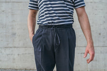 Laden Sie das Bild in den Galerie-Viewer, Close-up of men's navy Japanese seersucker trousers showing elastic waistband, drawstring and single forward pleat