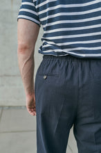 Laden Sie das Bild in den Galerie-Viewer, Rear close-up of navy drawstring trousers showing hidden elastic waistband and clean tailored finish