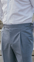 Load image into Gallery viewer, Gray pleated pants with side adjusters worn with a striped shirt on a neutral background