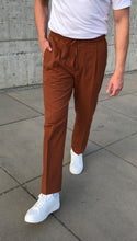 Laden Sie das Bild in den Galerie-Viewer, Detail of the elasticated waistband on rust terracotta trousers